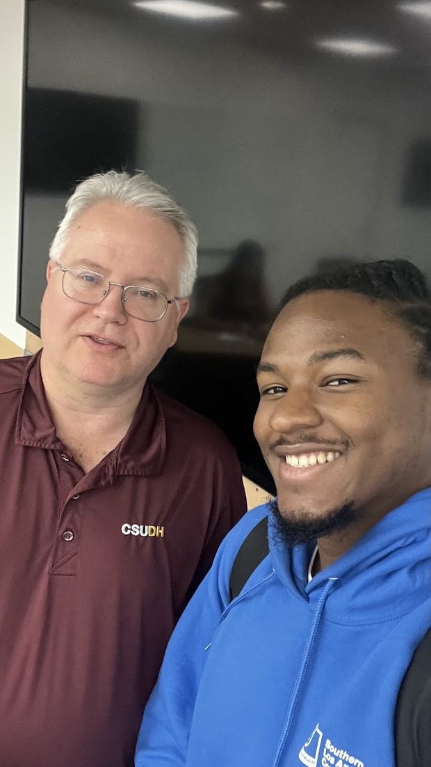 Thomas Norman with a smiling student in a Southern LA College hoodie